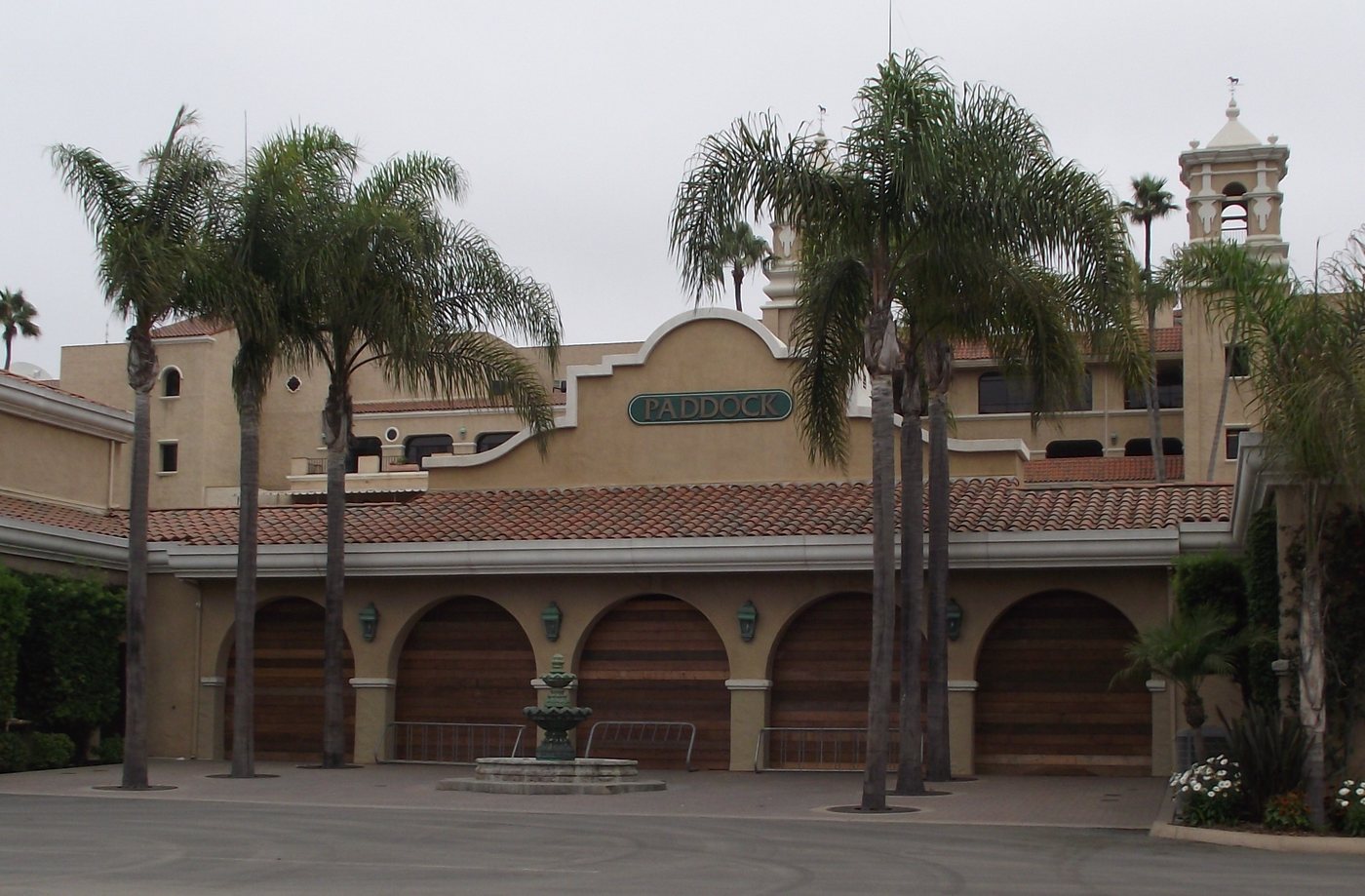 The Spanish Colonial Revival paddock building at the Del Mar Fairgrounds, with tile roofs, arches, palms and a bell tower