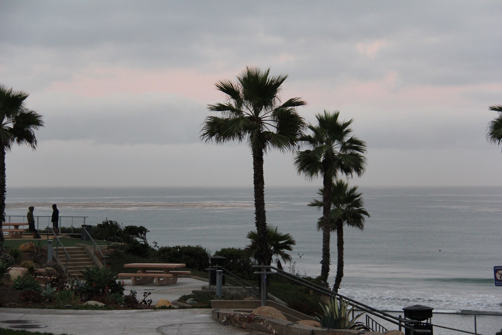 Fletcher Cove in Solana Beach photographed in 2013, the park at the top of the cut in the bluff with palms, steps and railings leading down through the gap to the sand and the ocean beyond