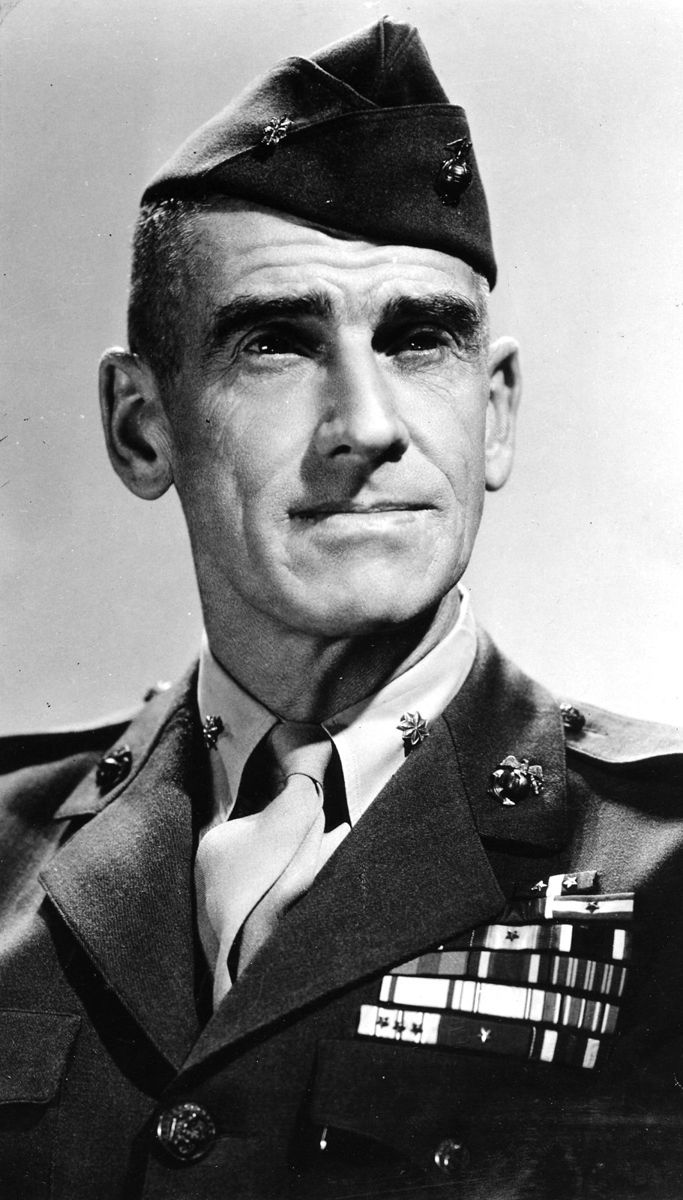 A head and shoulders portrait of a lean Marine officer in a garrison cap and a dress uniform with rows of ribbons