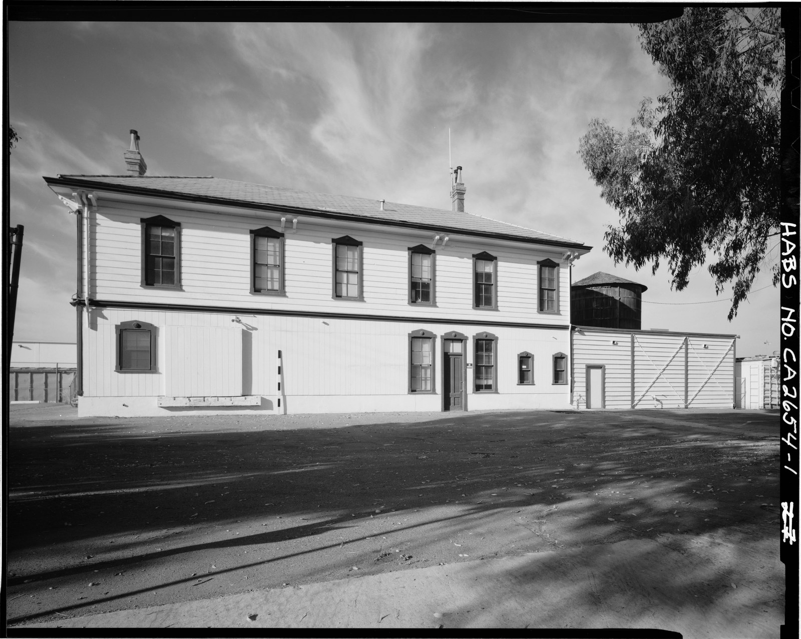 The east elevation of the National City railroad depot, a two story Italianate wood building with tall narrow windows and wide overhanging eaves