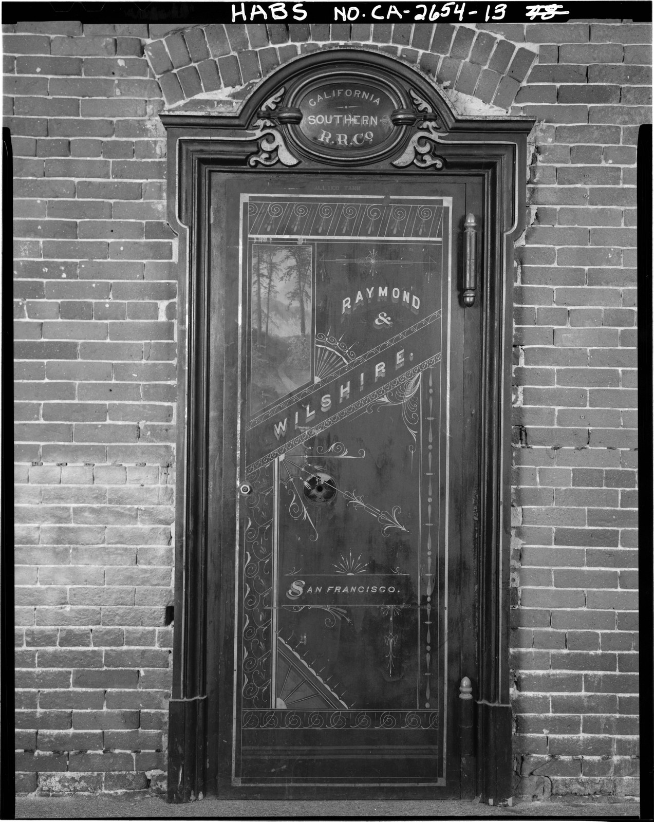 The painted iron door of the railroad safe inside the National City depot, set in an original 1882 brick wall, lettered California Southern R.R. Co.