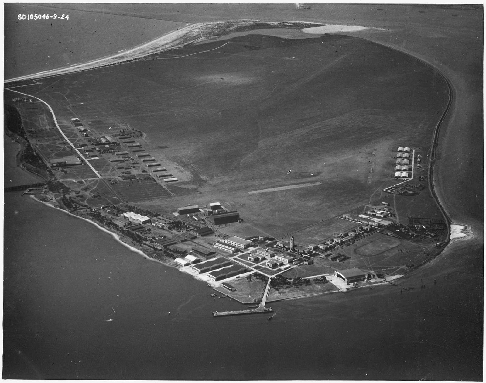 An aerial photograph of North Island in San Diego Bay taken in September 1924, showing the flat island with the naval air station buildings along its shore and open water separating it from Coronado