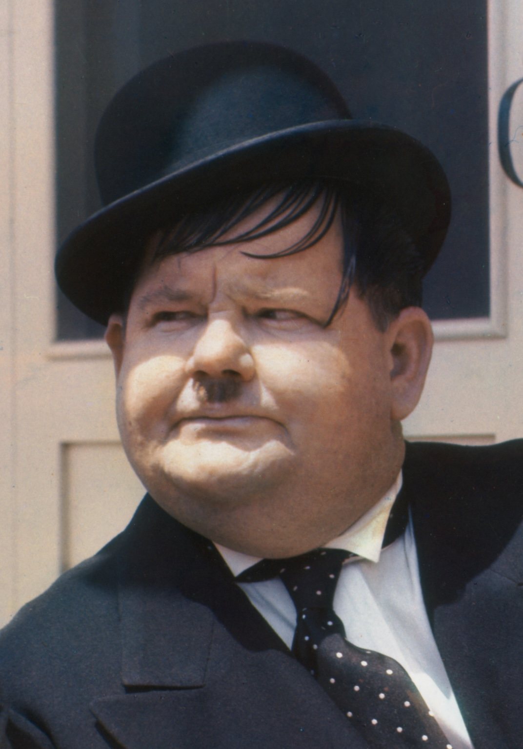 Color portrait of Oliver Hardy in a bowler hat and dark suit, photographed in 1938