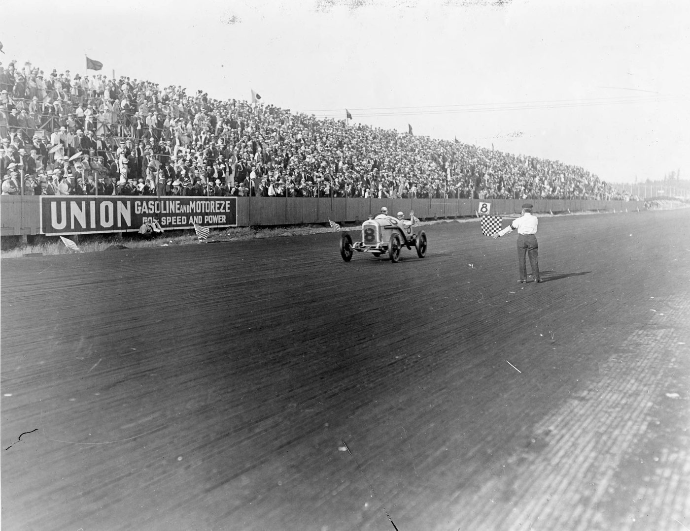 Earl Cooper takes the checkered flag in the number 8 Stutz. Photographed at Tacoma, not Point Loma, six months after he won here