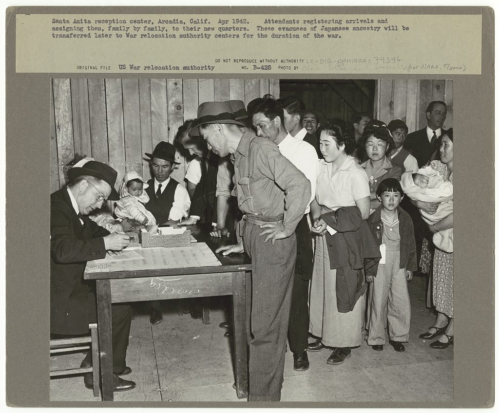 Attendants registering arrivals at the Santa Anita reception center in Arcadia, California, assigning them family by family to quarters, April 1942