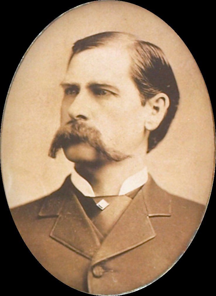 An oval studio portrait of a man in his late thirties with a heavy drooping mustache, a dark suit and a high white collar
