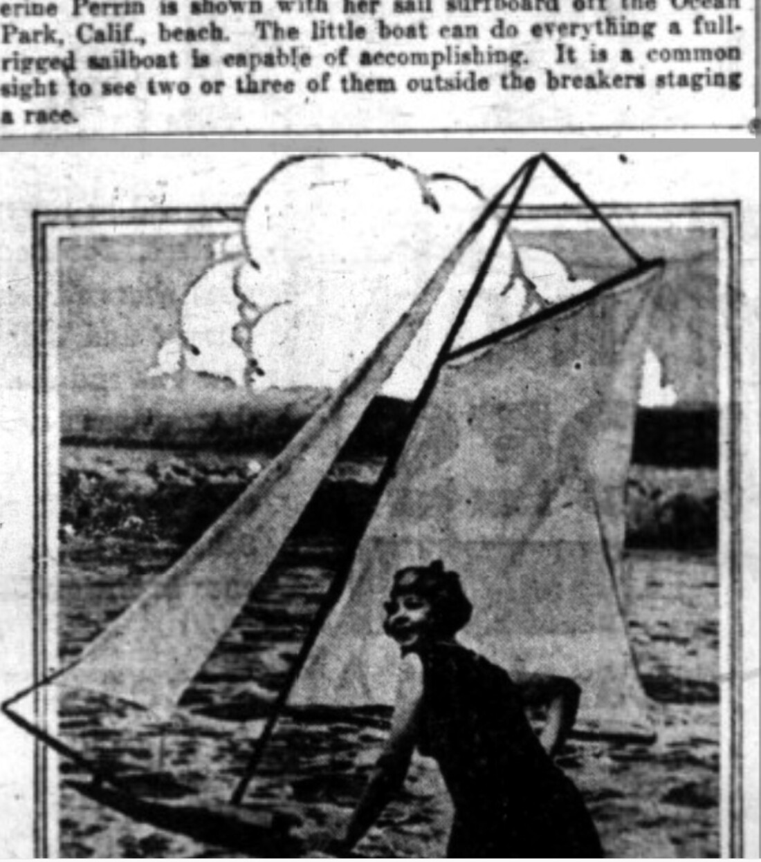 A 1921 newspaper photograph of a woman kneeling on a surfboard rigged with a tall triangular sail, in shallow water off a beach, with clouds behind her.