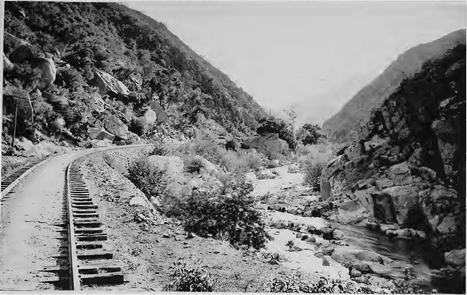 The California Southern Railroad track on a low embankment beside a dry boulder creek bed in Temecula Canyon, photographed in 1887