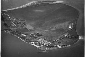 An aerial photograph of North Island in San Diego Bay taken in September 1924, showing the flat island with the naval air station buildings along its shore and open water separating it from Coronado